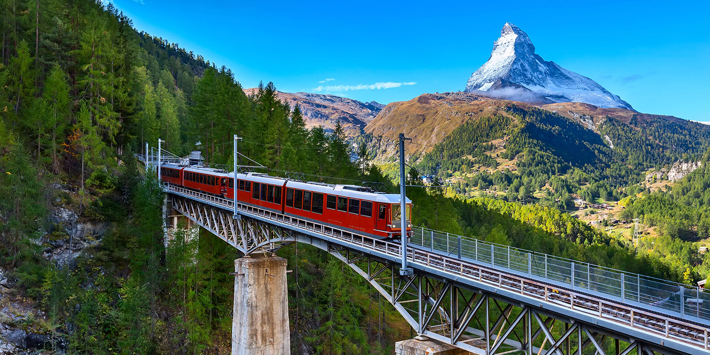 Red Gornergrat train riding through the hills of Zermatt, Switzerland