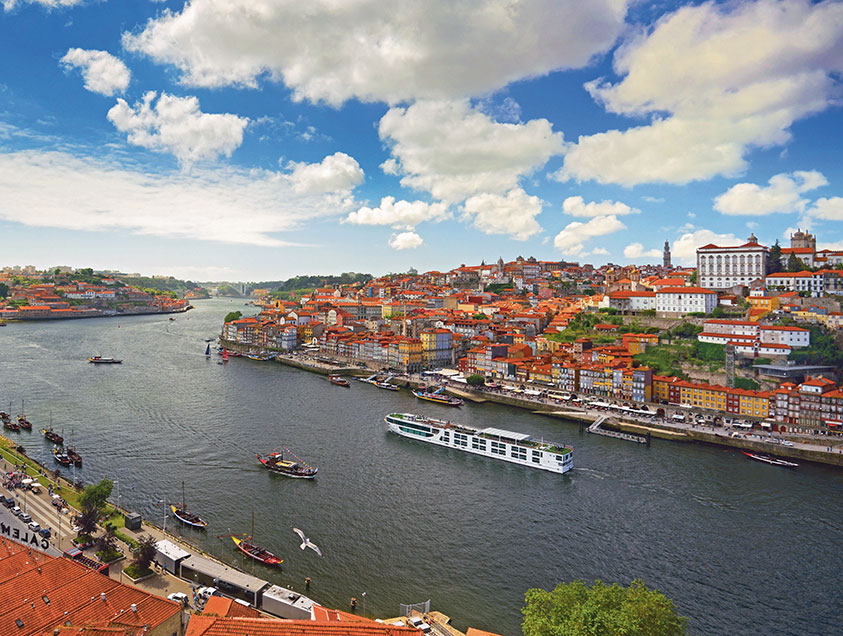 Scenic Azure ship cruising on the Douro River next to the colourful town of Porto. 