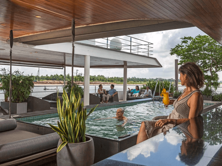 Guests swimming and sitting around the Vitality Pool on the Scenic Spirit ship