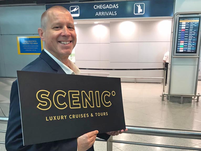 Scenic employee welcoming guests at airport arrivals