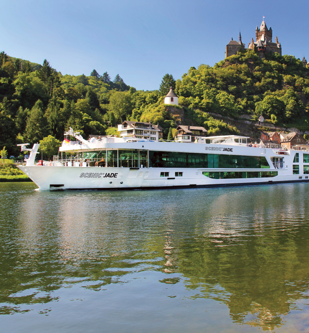 River cruise sailing on european river with tree covered hillside behind